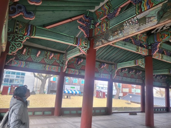 '관덕정 창방(들보)의 그림을 확인하고 사진을 찍는 "시절한시" 저자(필자 촬영)
